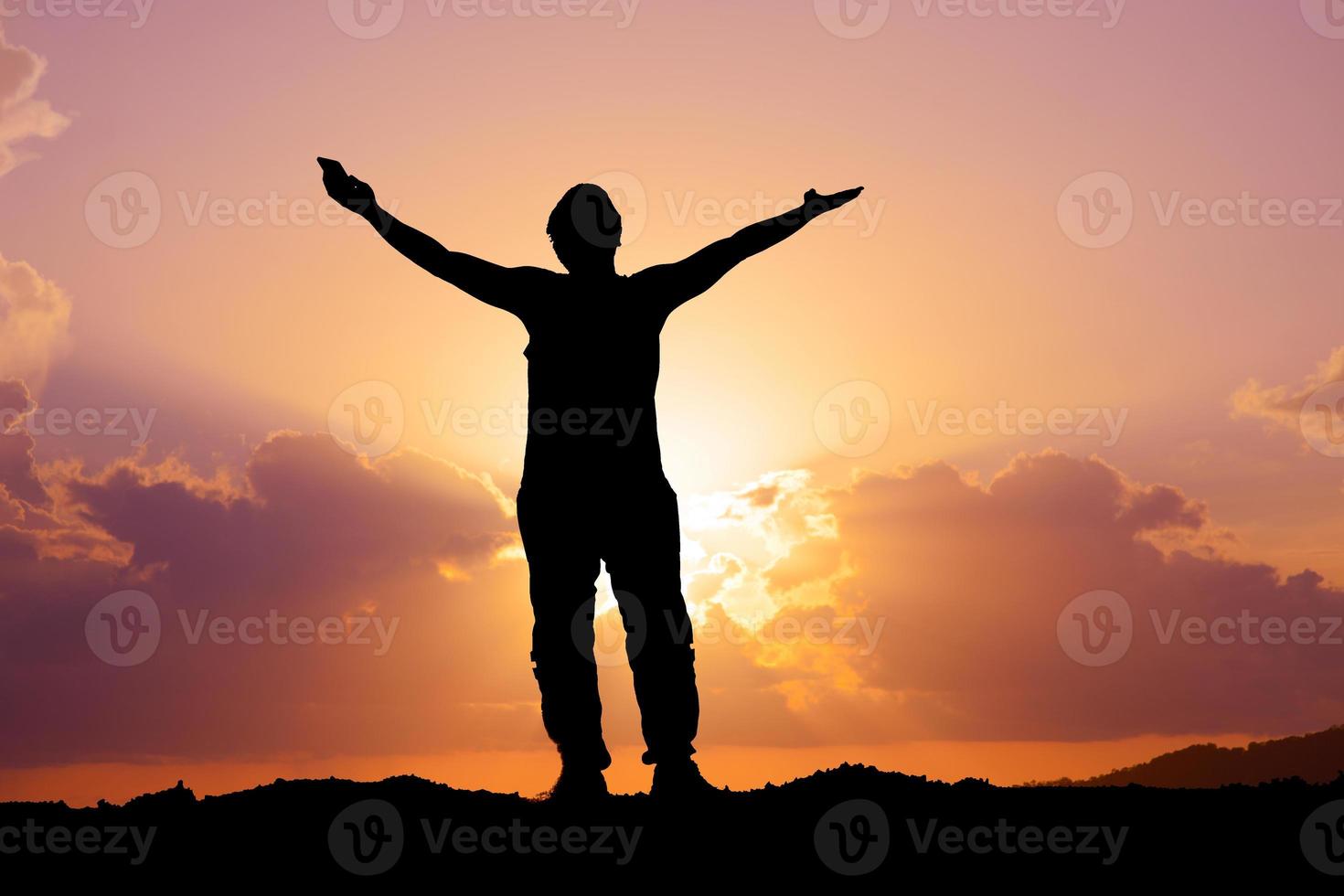 Silhouettes of men raising their hands in happiness and freedom on the mountain. photo