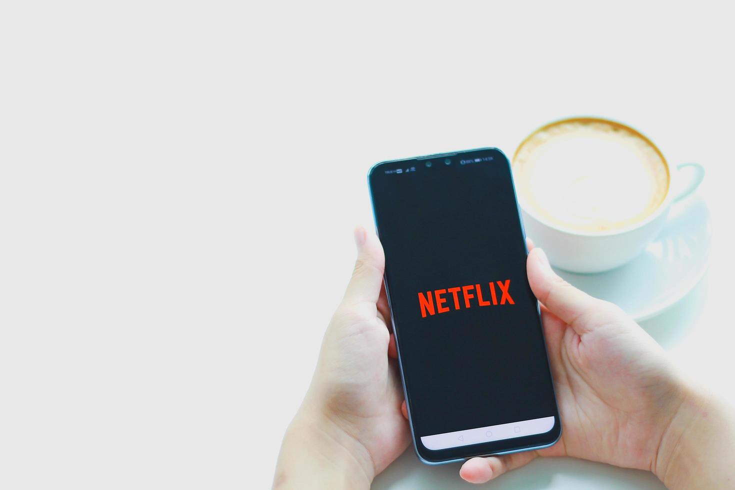 CHIANG MAI, THAILAND - august 23, 2020 - A woman hand holding Smart Phone with Netflix logo on Huawei mobile phone. Netflix is a global provider of streaming movies and TV series. photo