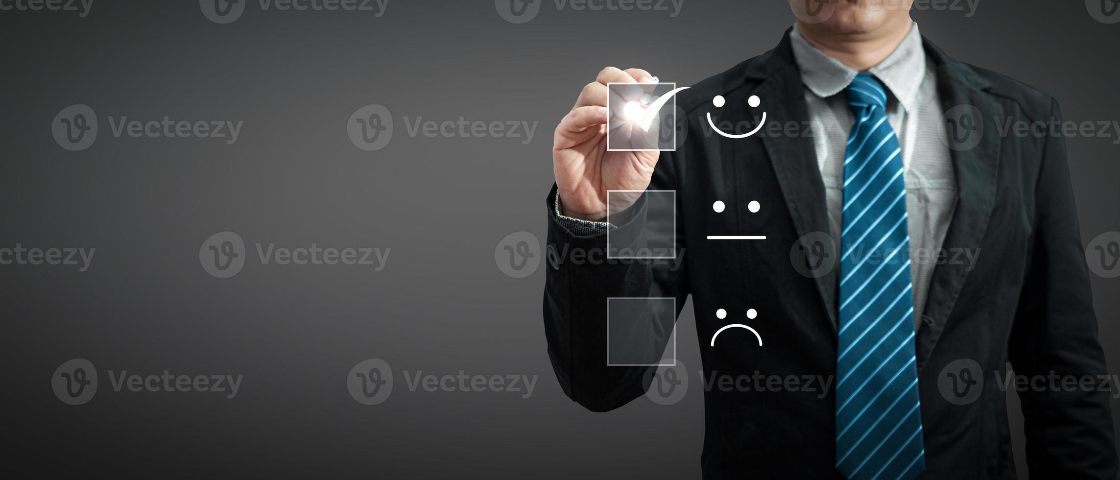 a businessman in a suit holding a pen touching the virtual screen on the happy Smiley face icon to give satisfaction in service.rating very impressed.Customer service and Satisfaction concept photo