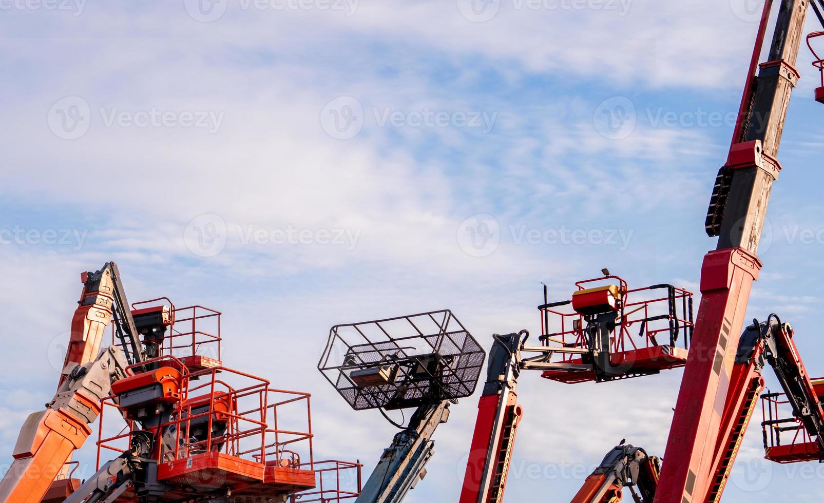 Articulated boom lift. Aerial platform lift. Telescopic boom lift against blue sky. Mobile construction crane for rent and sale. Maintenance and repair hydraulic boom lift service. Crane dealership. photo