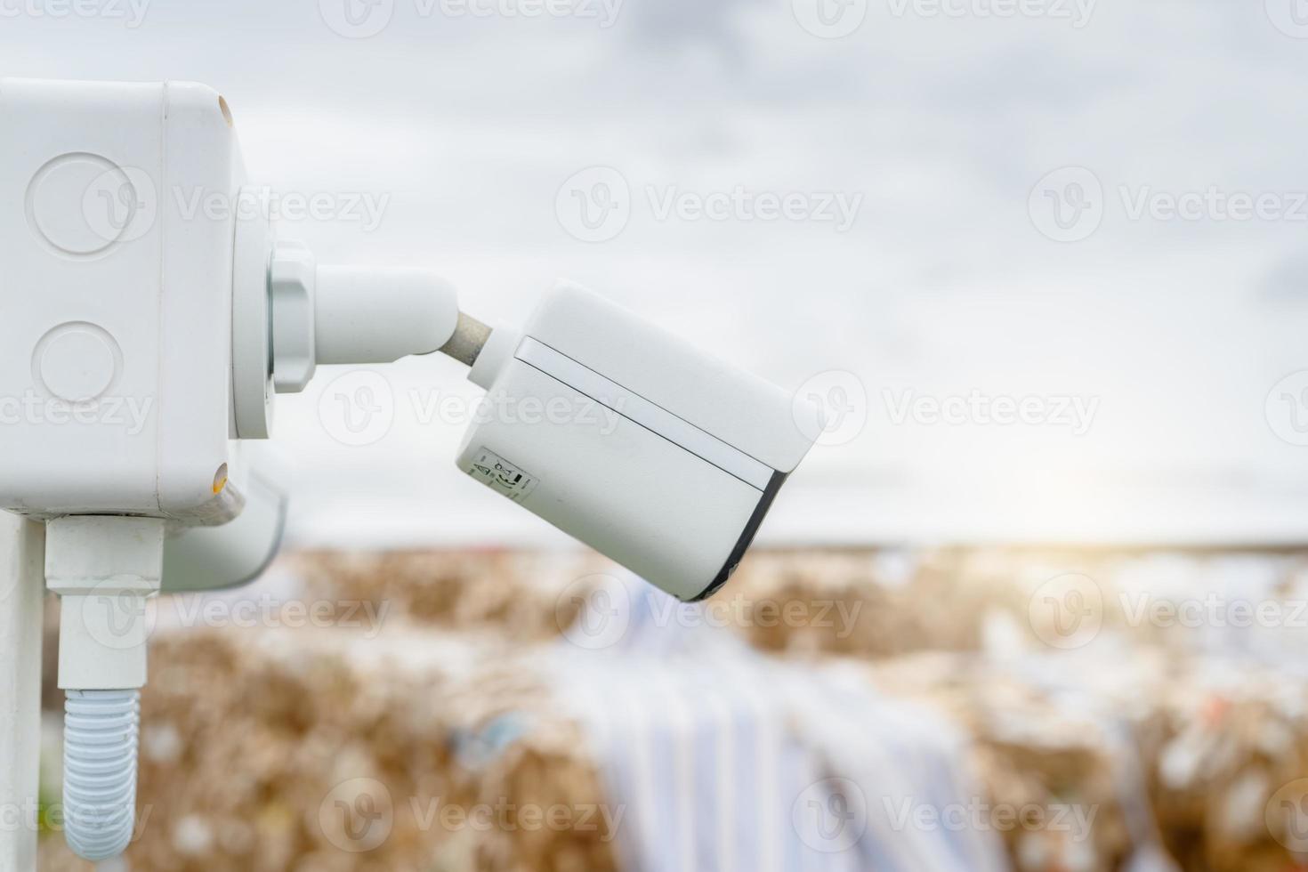 Side view of white CCTV security camera video system for safety at a paper recycling factory. Closed-circuit television. CCTV electronic security system. Video surveillance camera technology. photo