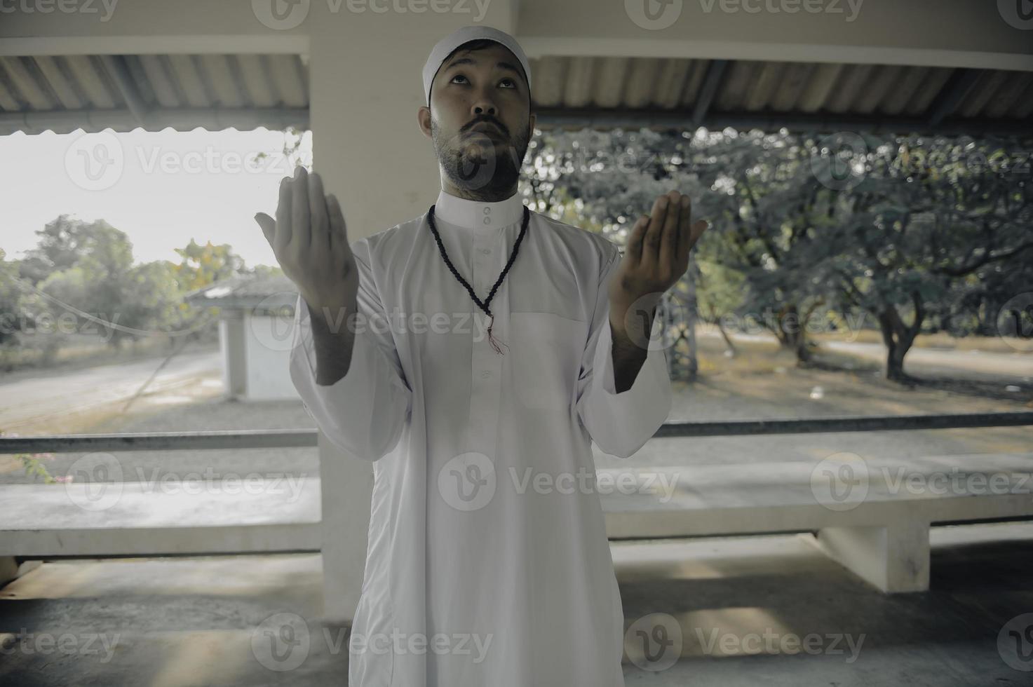 Young asian muslim man praying on sunset,Ramadan festival concept photo