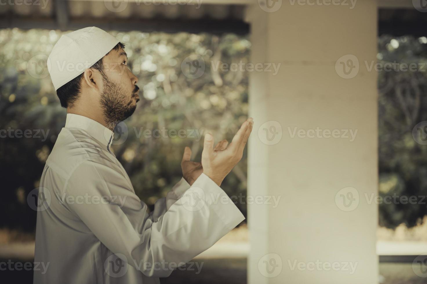 Young asian muslim man praying on sunset,Ramadan festival concept photo
