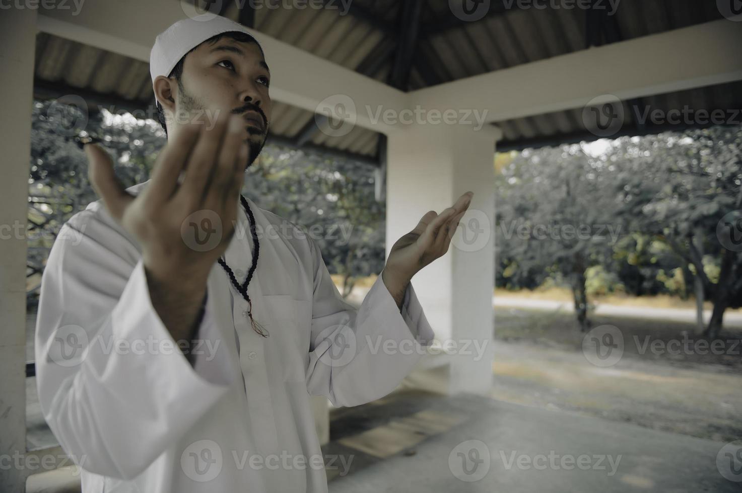 Young asian muslim man praying on sunset,Ramadan festival concept photo