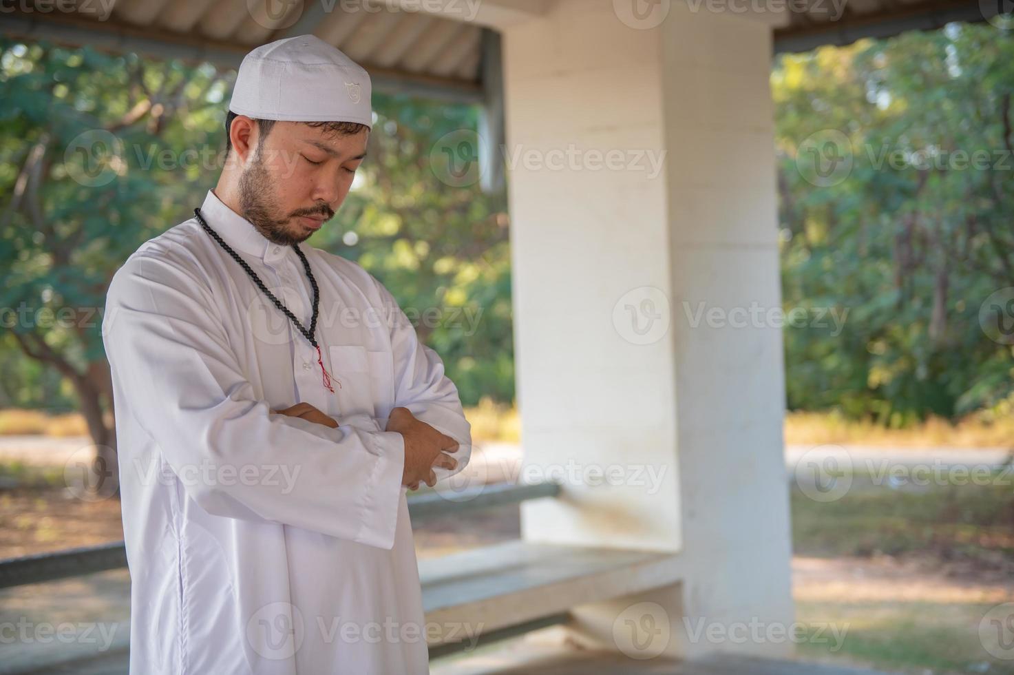 Young asian muslim man praying on sunset,Ramadan festival concept photo