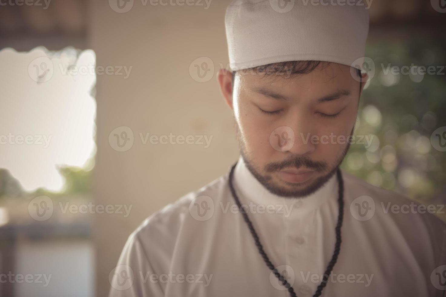 Young asian muslim man praying on sunset,Ramadan festival concept photo