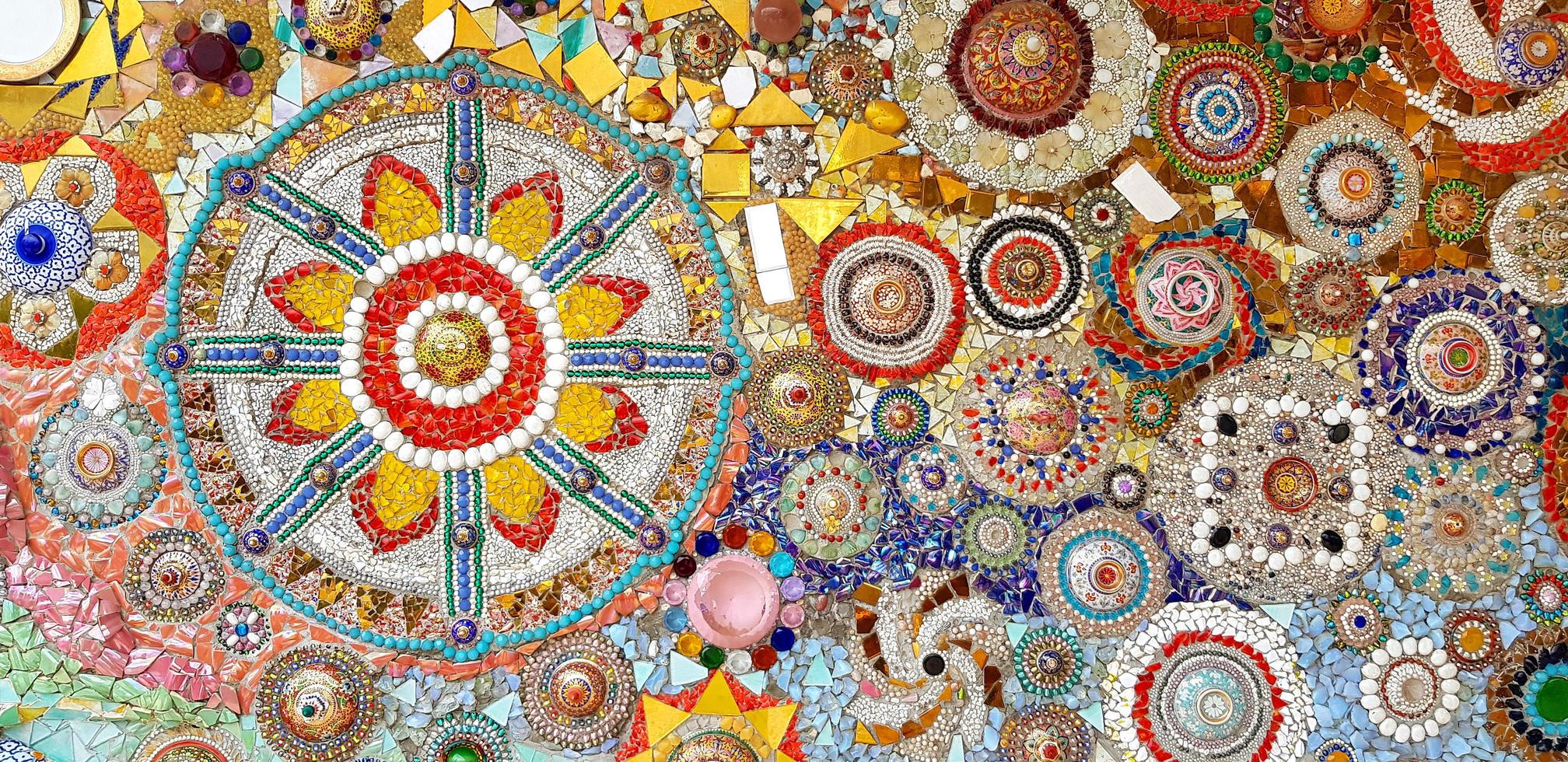 Colorful wall decorated with multicolor stone, gravel and gem for background at Wat Phra That Pha Son Kaew. Abstract of art design with broken tile for wallpaper. photo