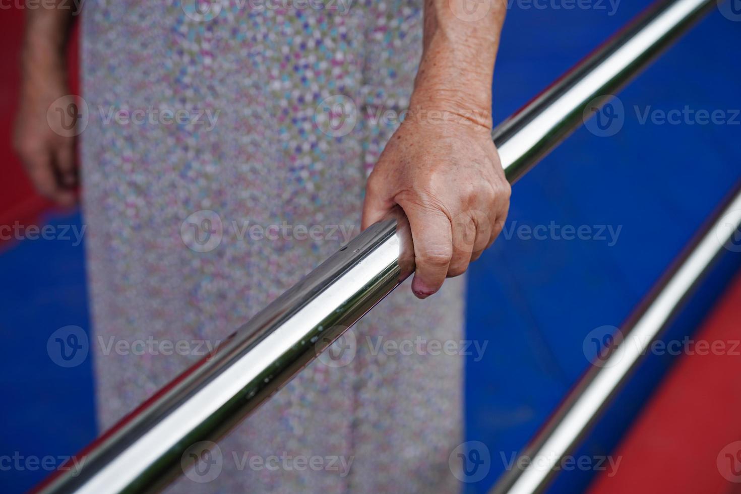 Asian elderly old woman patient use support rail on ramp, handrail safety grab bar, security in nursing hospital. photo