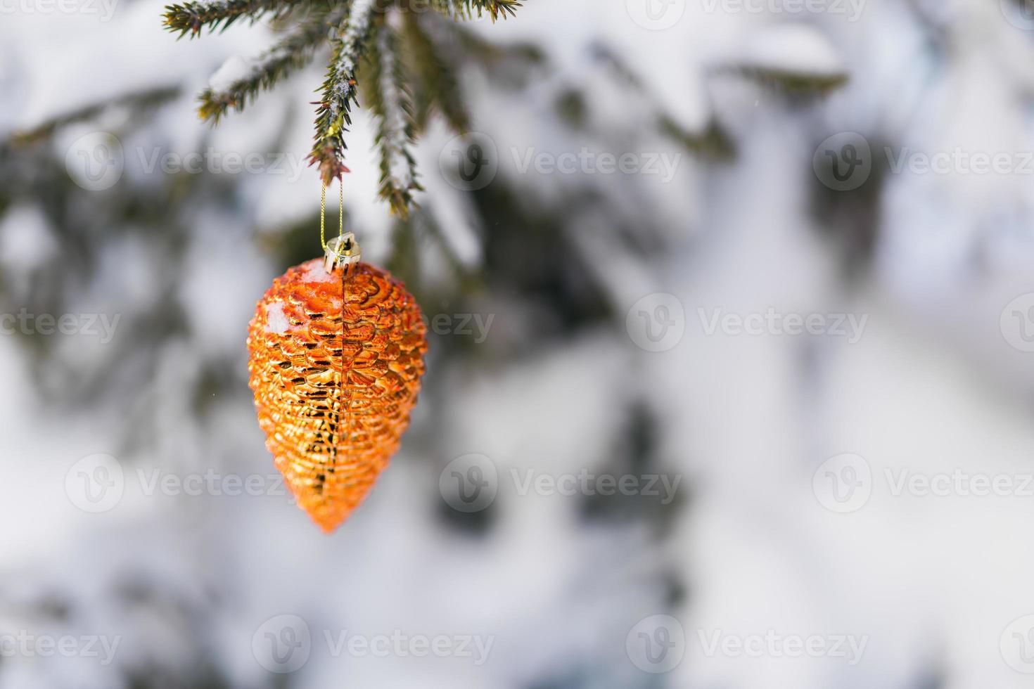 Ornament fir tree cone Christmas tree decoration toy hanging on spruce branch with snow branches on background. Copy space. Close-up. photo