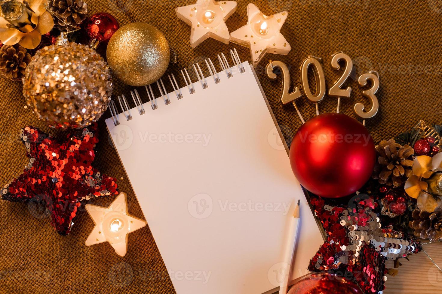 cuaderno con páginas en blanco con juguetes, regalos y números de año nuevo 2023. planes y sueños para el nuevo año, espacio para texto foto