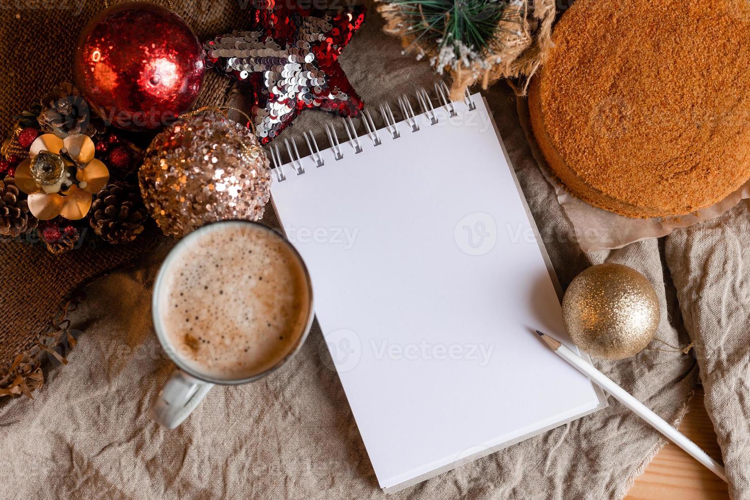 un cuaderno con páginas vacías sobre una mesa de madera con café y pastel de miel casero. un cuaderno para recetas, cocinando en casa. pasteles caseros, espacio para texto foto