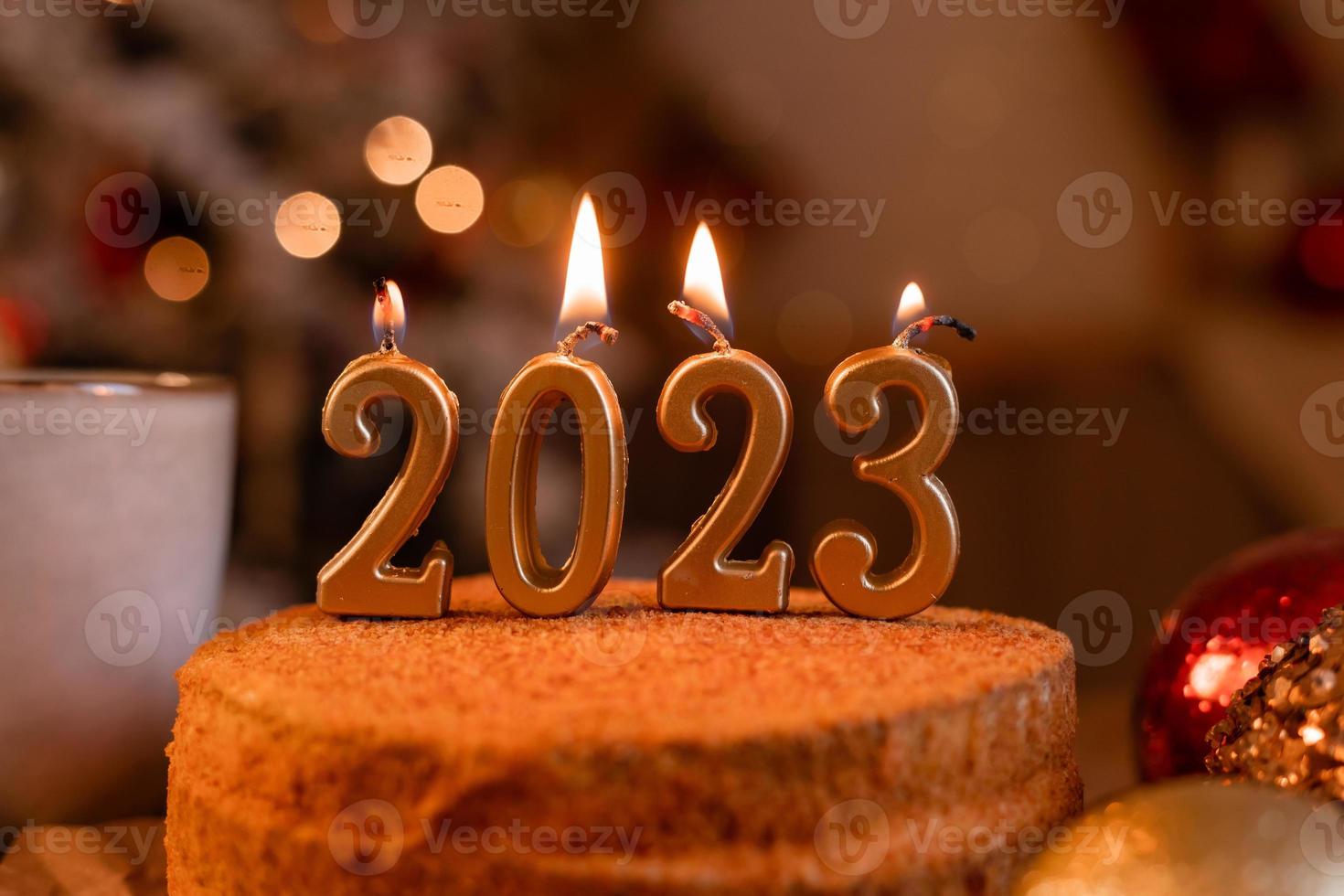 pastel de miel casero en la cocina con velas 2023. acogedor año nuevo en casa. Feliz Navidad. foto de alta calidad