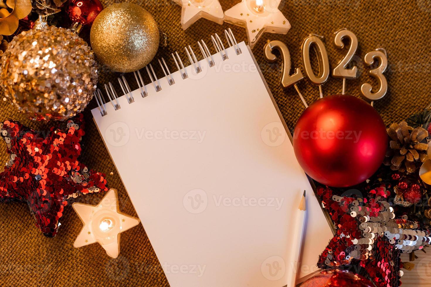 cuaderno con páginas en blanco con juguetes, regalos y números de año nuevo 2023. planes y sueños para el nuevo año, espacio para texto foto