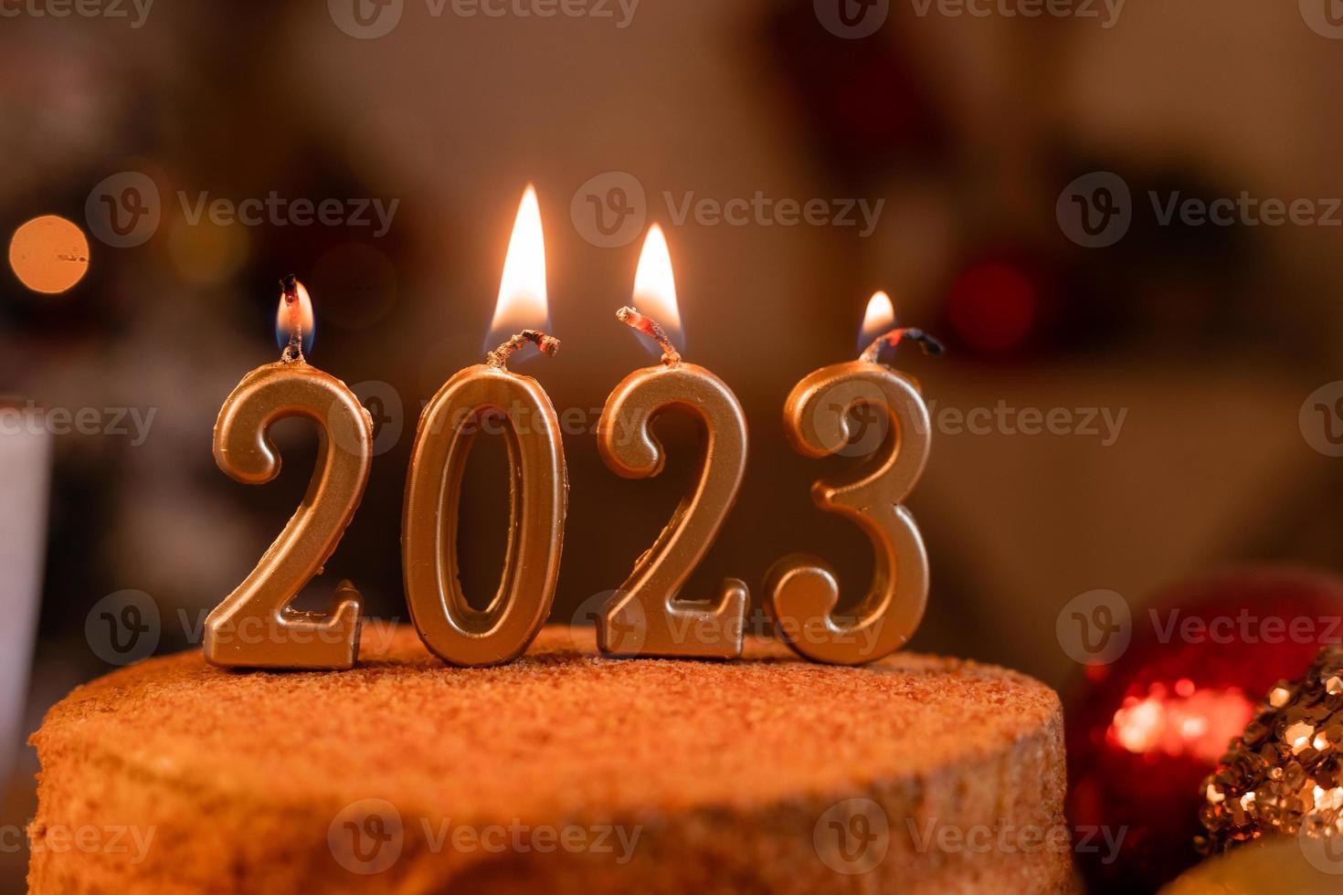 pastel de miel casero en la cocina con velas 2023. acogedor año nuevo en casa. Feliz Navidad. foto de alta calidad
