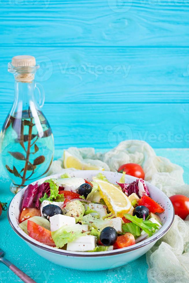 Fresh salad with tomato, lettuce, avocado, olives, feta and pepper. Diet eating photo