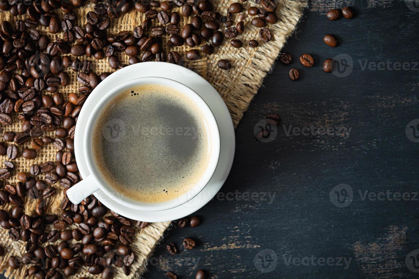 taza de café con granos de café sobre fondo oscuro. taza de café bebida caliente foto