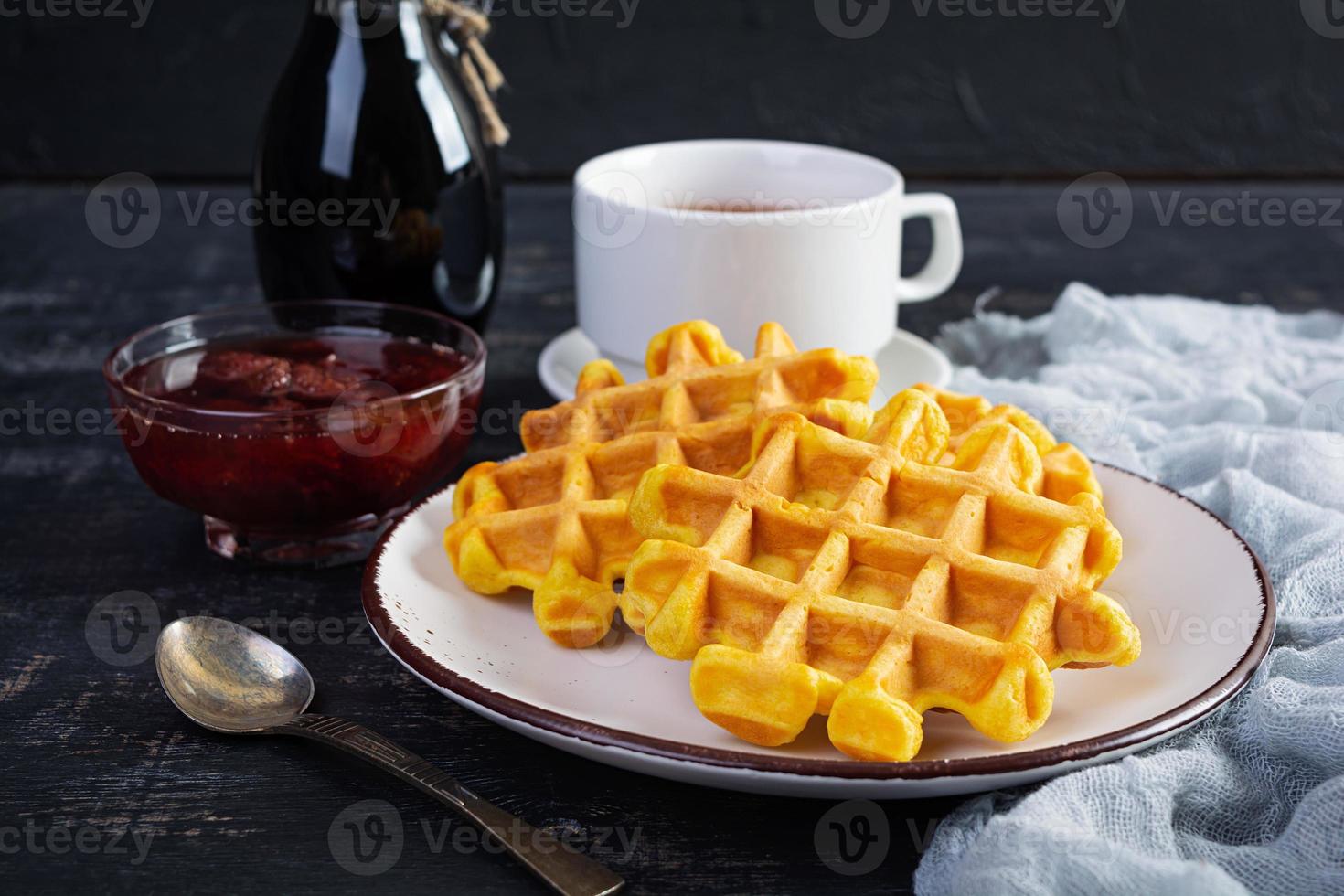 gofres dulces de calabaza con mermelada de fresa. delicioso desayuno con gofres belgas foto