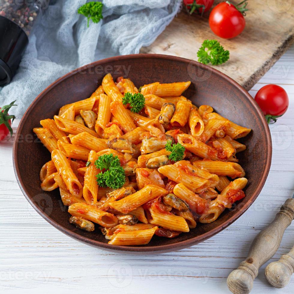 Pasta penne in marinara sauce with mussels, onion and parsley. Classic Italian pasta penne photo