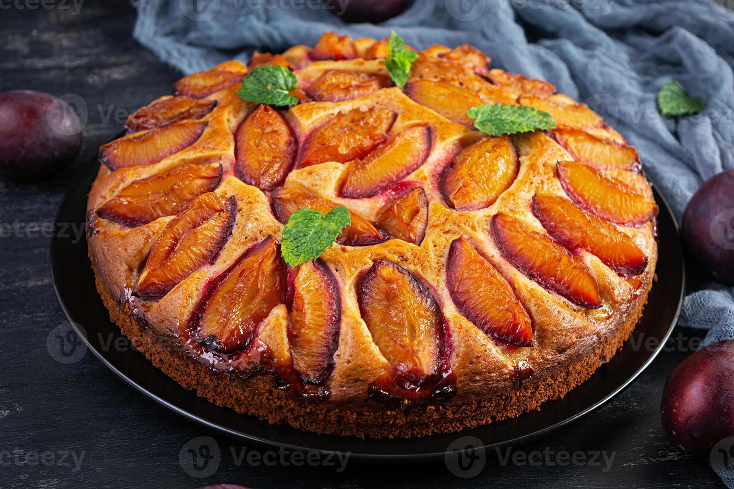 Delicious plum cake on wooden background. Homemade plum pie photo