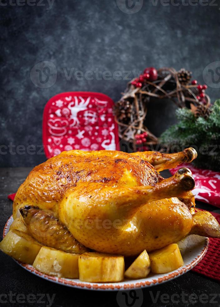 pollo asado y patata con decoración navideña. comida tradicional para navidad o día de acción de gracias foto