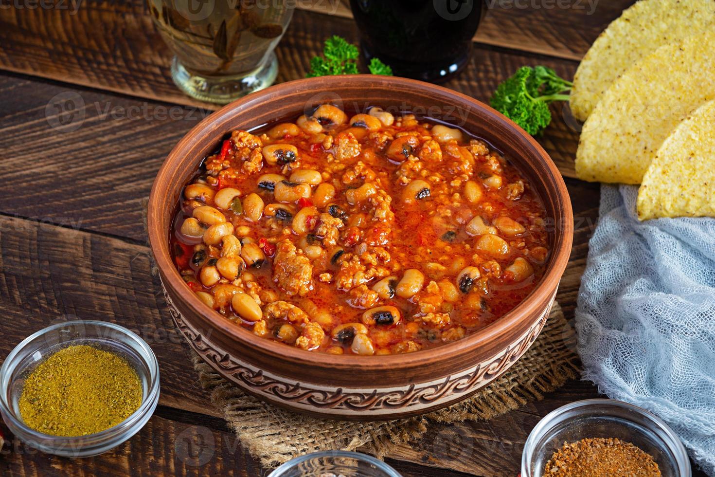 chili con carne en un bol sobre fondo de madera. cocina mexicana foto