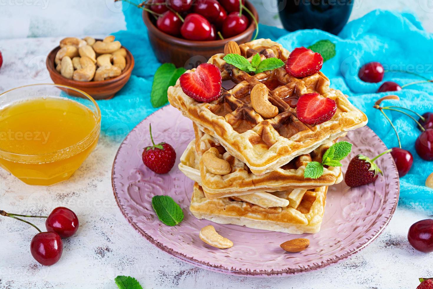 delicioso desayuno con gofres belgas. gofres con mermelada de fresa y bayas foto