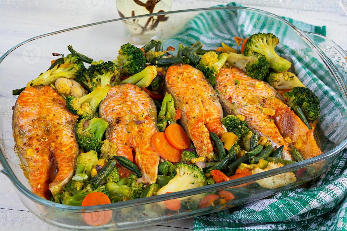 filete de salmón al horno con vegetales verdes. filete de pescado con hierbas y verduras foto