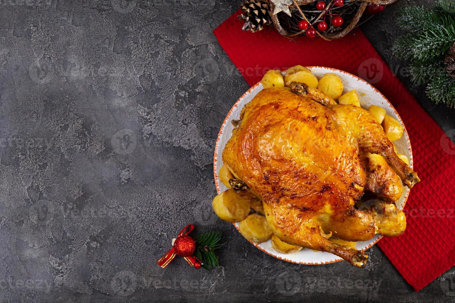 pollo asado y patata con decoración navideña. comida tradicional para navidad o día de acción de gracias foto