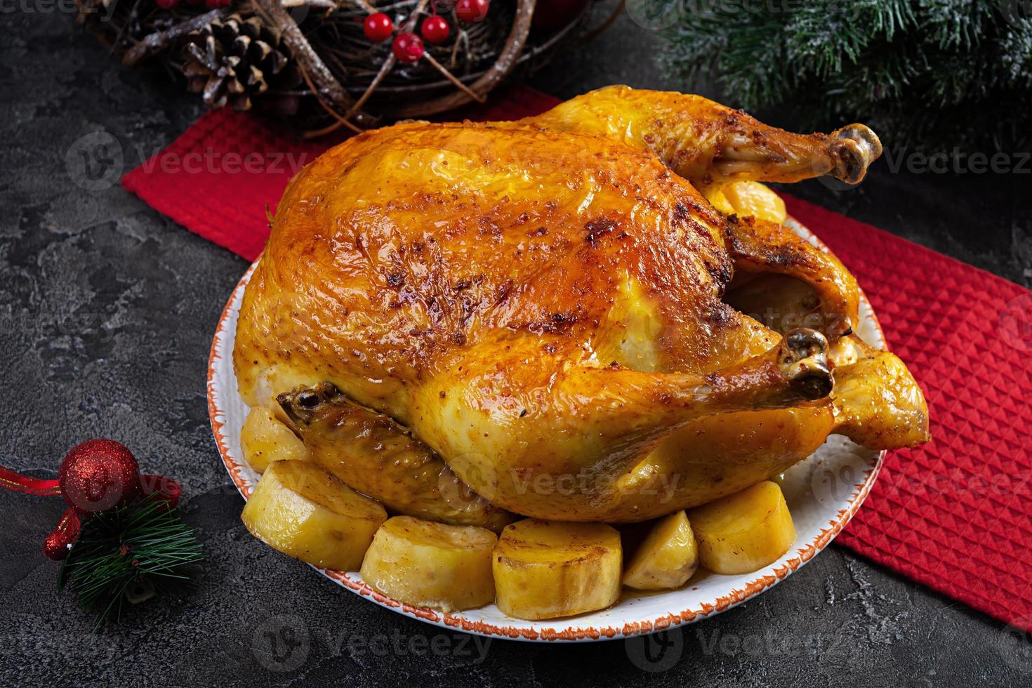 Roasted chicken and potato with Christmas decoration. Traditional food for Christmas or Thanksgiving day photo