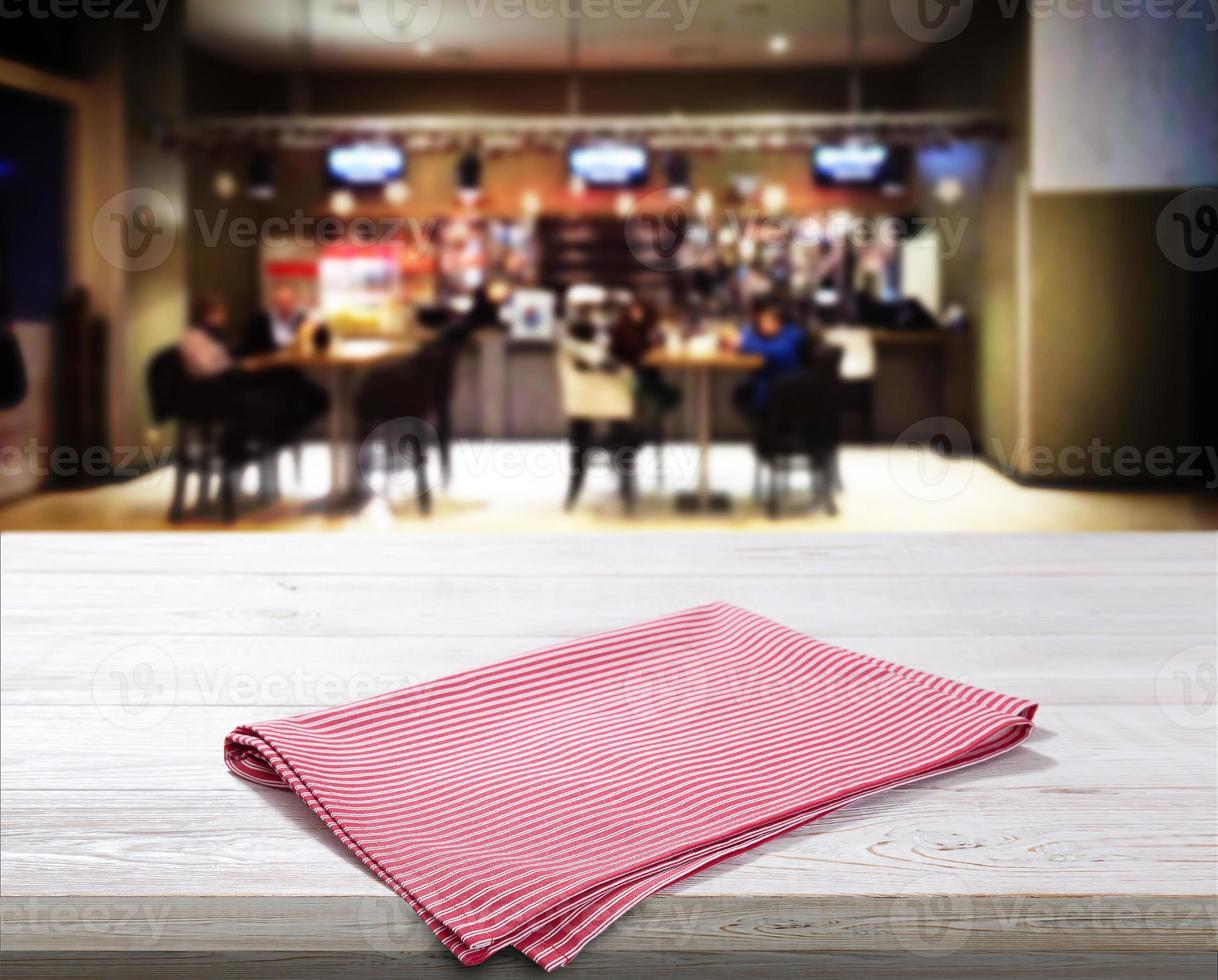 Red napkin on white wooden table top view photo