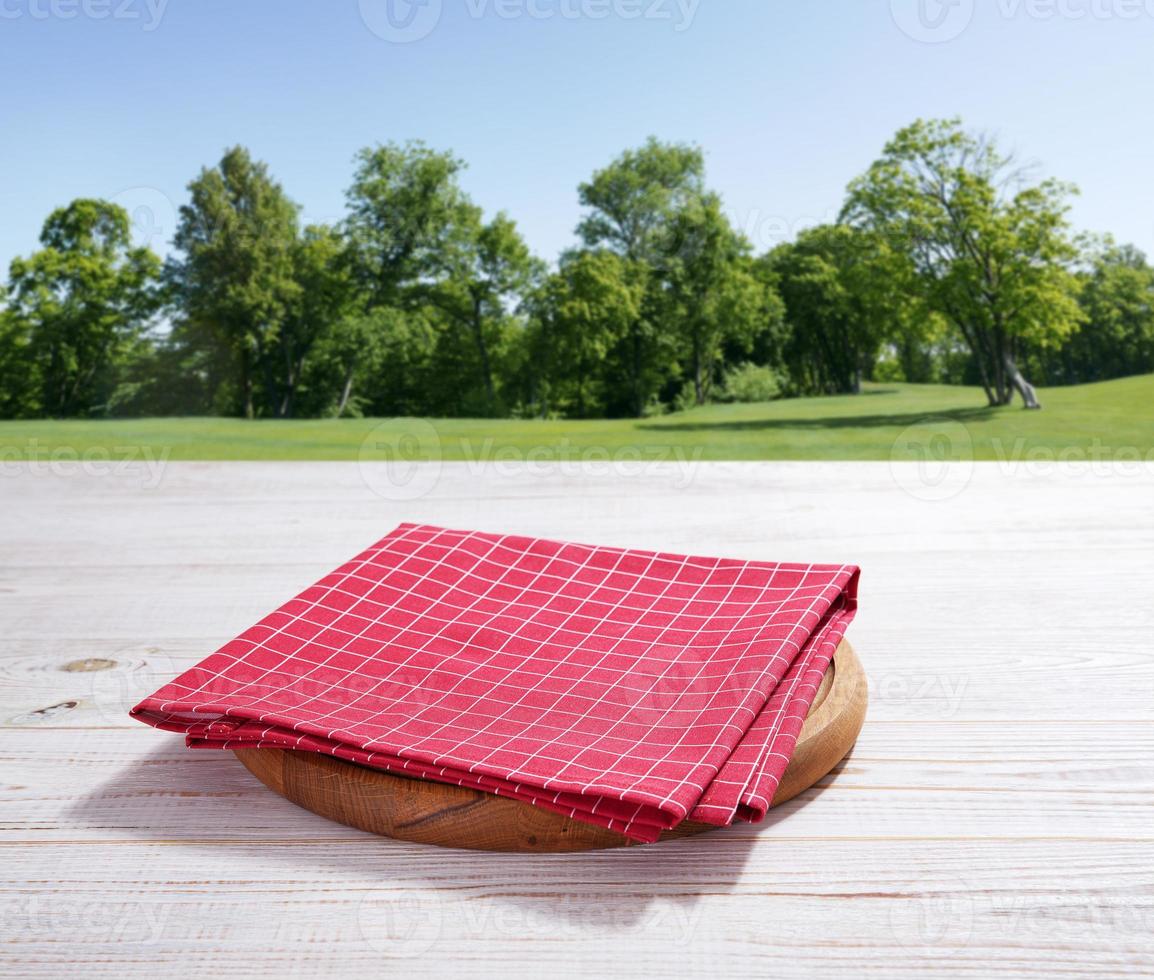 Empty pizza board and red napkin on white wooden photo