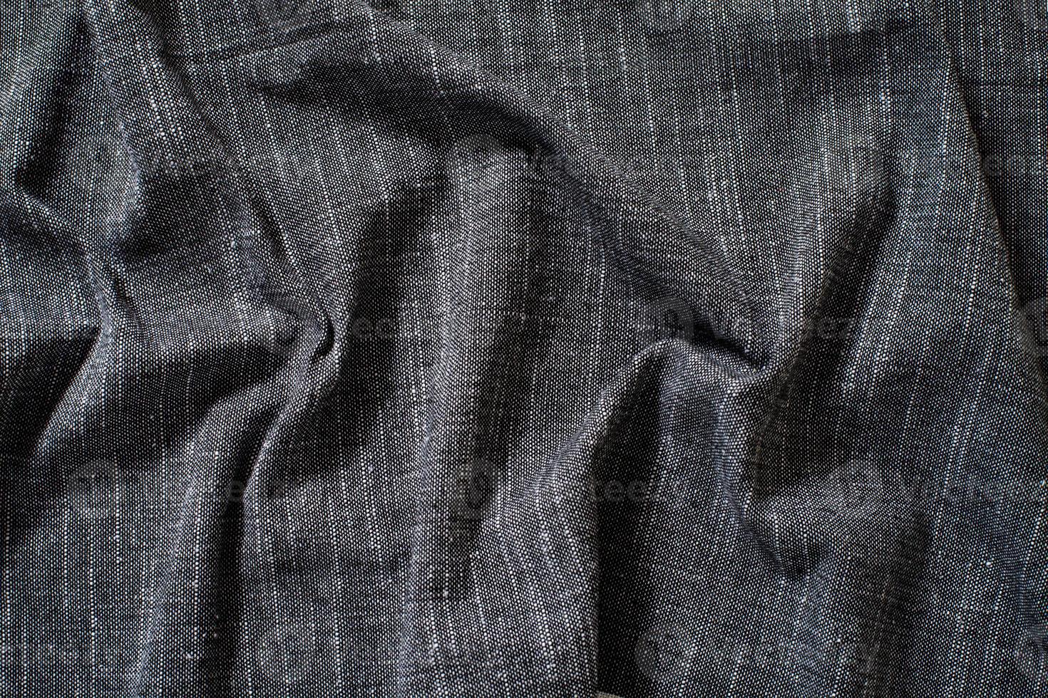 Dark rough fabric texture. Crumpled. photo