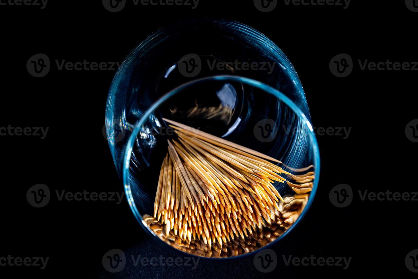 bamboo wooden toothpicks in glass jar, wine glass. in bucket. toothpicks on black background. front view toothpicks, dropped from hand, place for text, photo