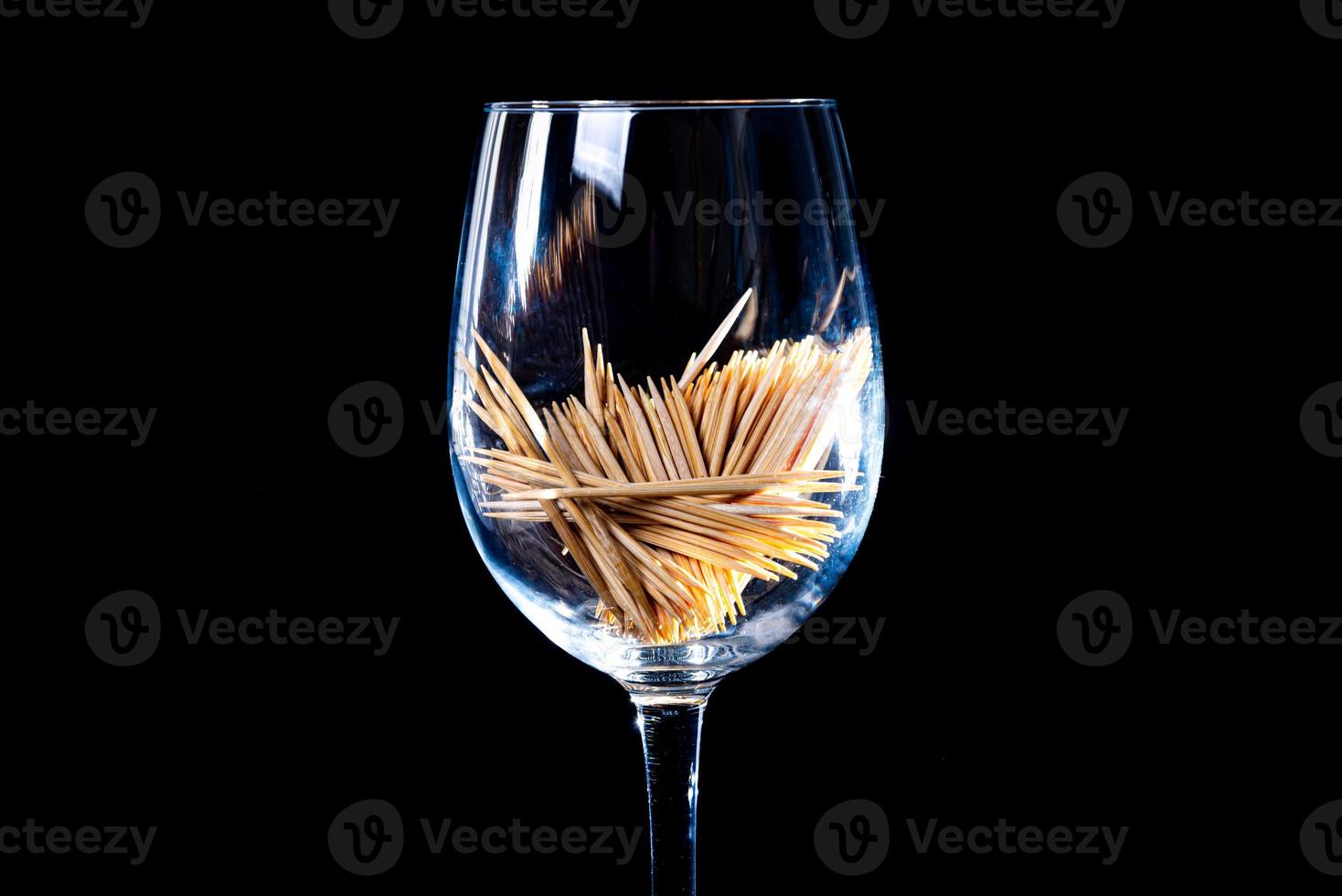 bamboo wooden toothpicks in glass jar, wine glass. in bucket. toothpicks on black background. front view toothpicks, dropped from hand, place for text, photo