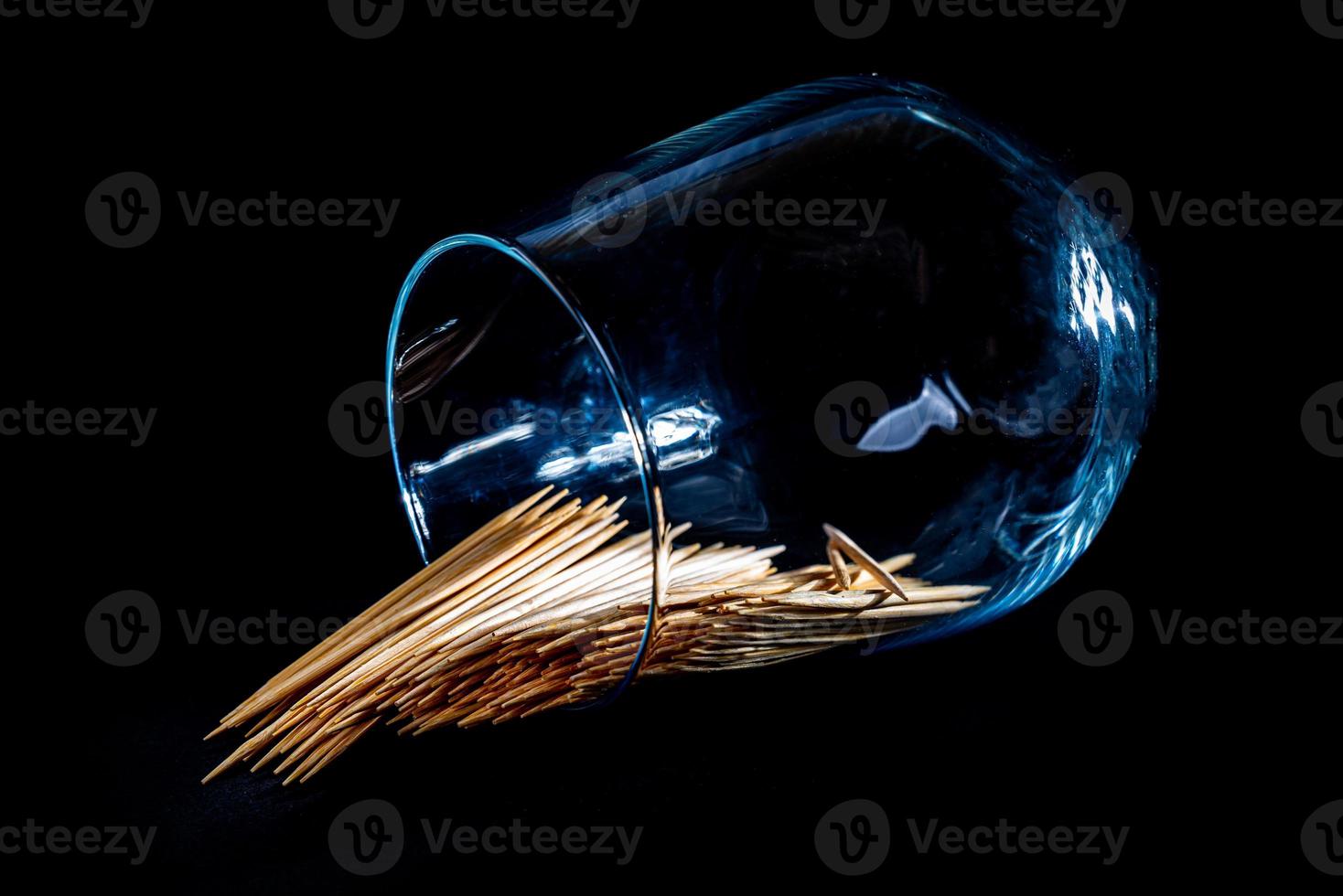 bamboo wooden toothpicks in glass jar, wine glass. in bucket. toothpicks on black background. front view toothpicks, dropped from hand, place for text, photo
