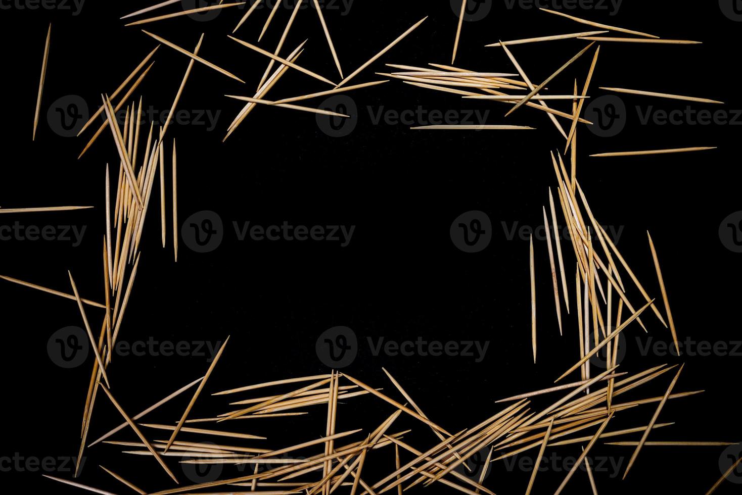 bamboo wooden toothpicks in glass jar, wine glass. in bucket. toothpicks on black background. front view toothpicks, dropped from hand, place for text, photo