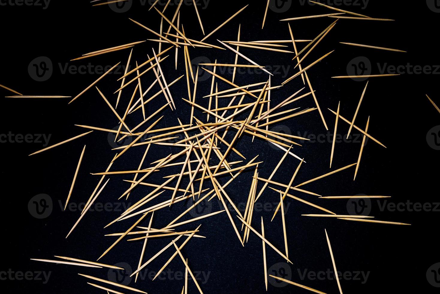 bamboo wooden toothpicks in glass jar, wine glass. in bucket. toothpicks on black background. front view toothpicks, dropped from hand, place for text, photo