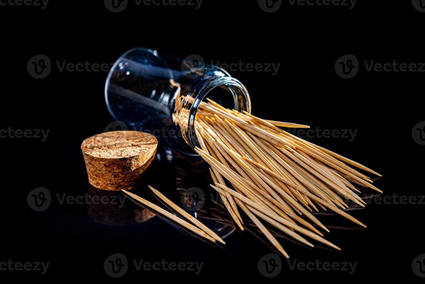 bamboo wooden toothpicks in glass jar, wine glass. in bucket. toothpicks on black background. front view toothpicks, dropped from hand, place for text, photo