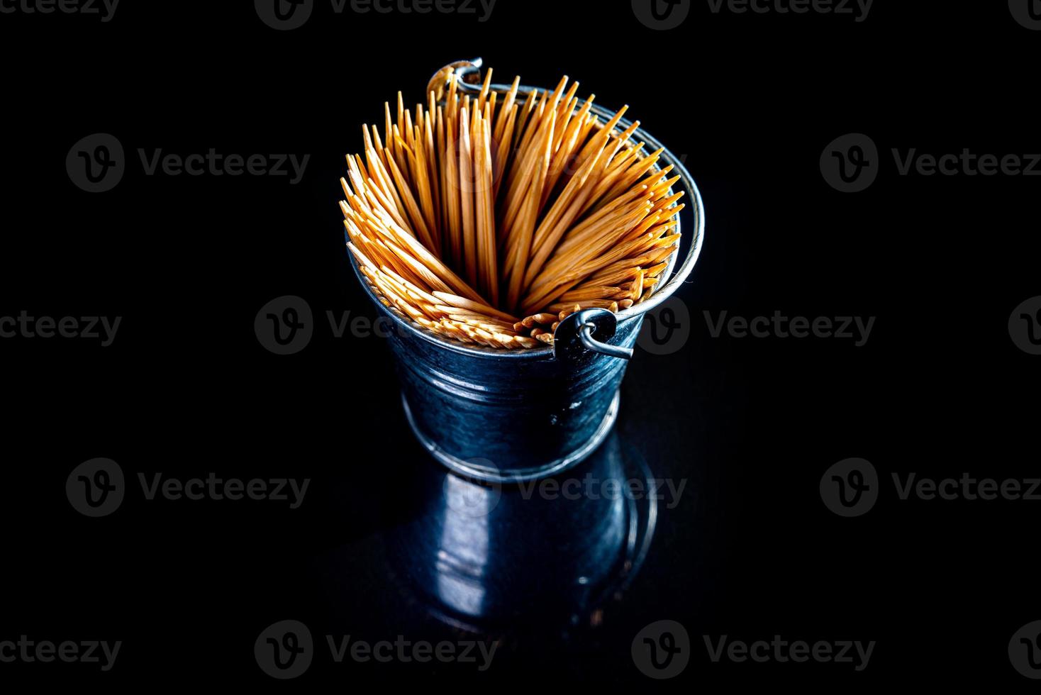 palillos de madera de bambú en frasco de vidrio, copa de vino. en cubo. palillos de dientes sobre fondo negro. palillos de vista frontal, caídos de la mano, lugar para texto, foto