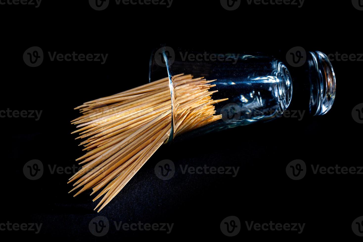 bamboo wooden toothpicks in glass jar, wine glass. in bucket. toothpicks on black background. front view toothpicks, dropped from hand, place for text, photo