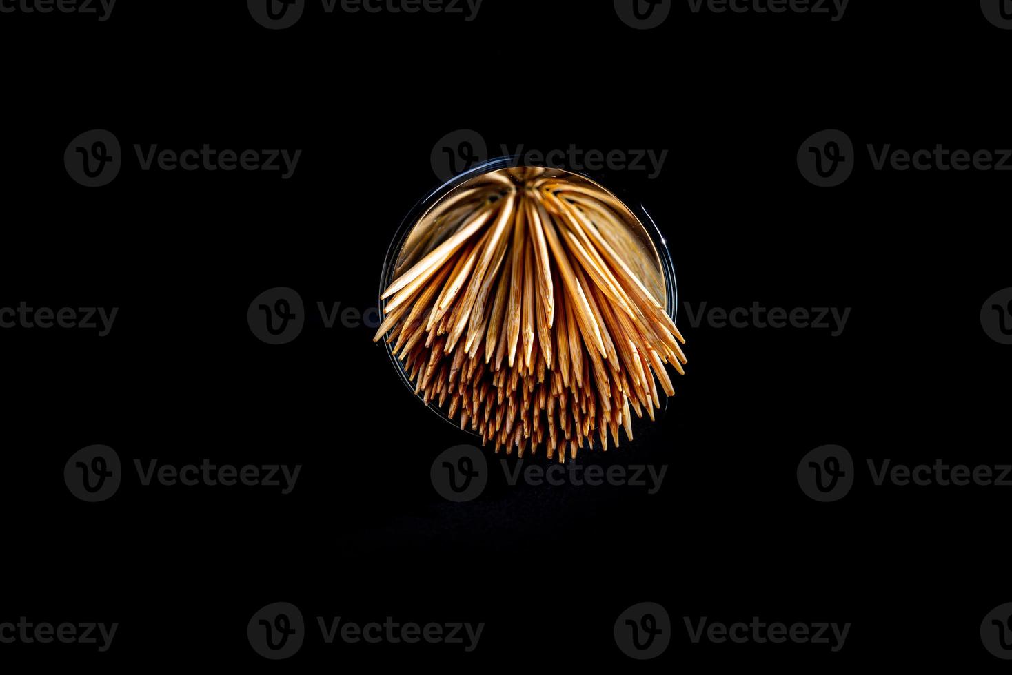 bamboo wooden toothpicks in glass jar, wine glass. in bucket. toothpicks on black background. front view toothpicks, dropped from hand, place for text, photo