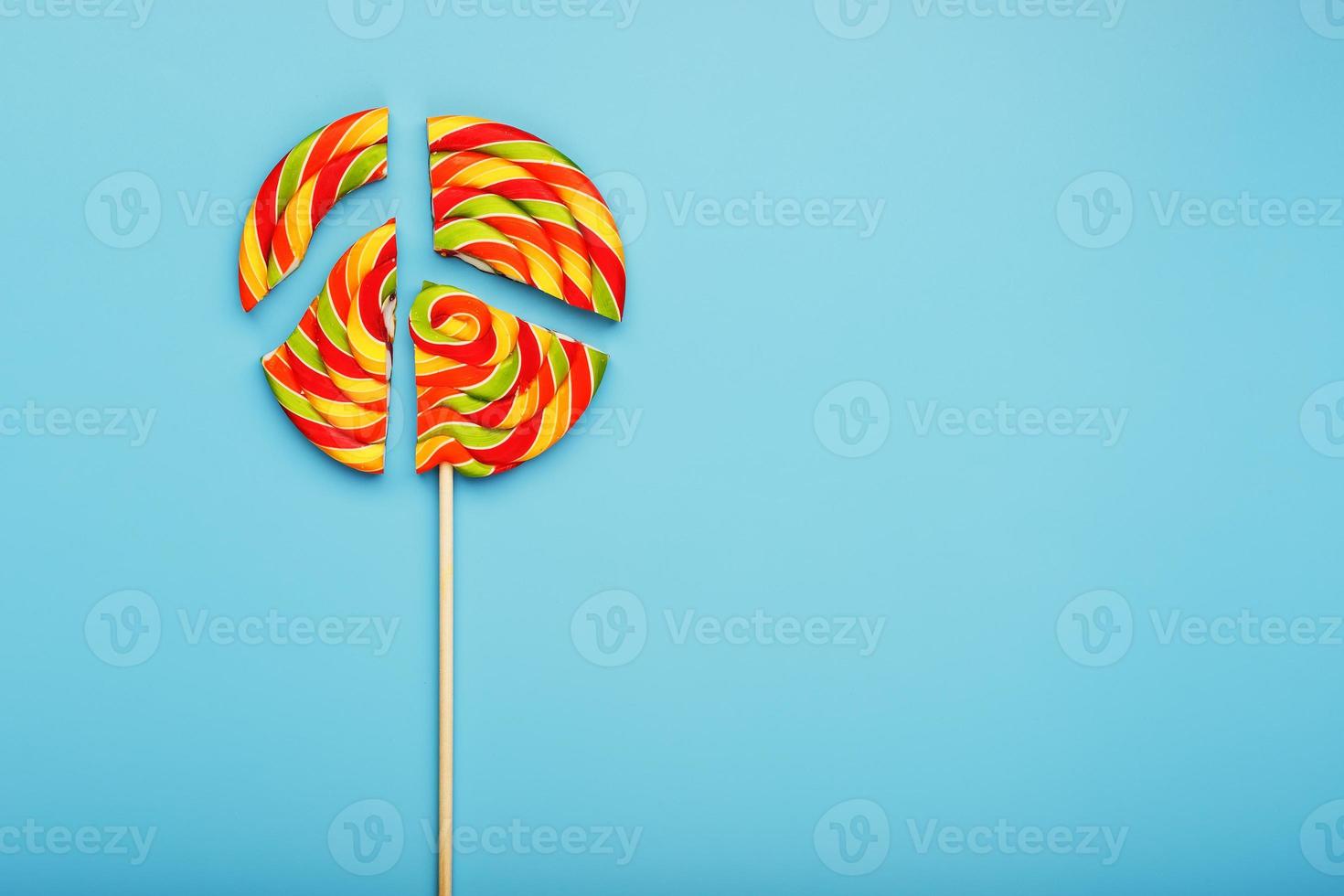 Lollipop broken into pieces on blue background, top view with copy space. photo