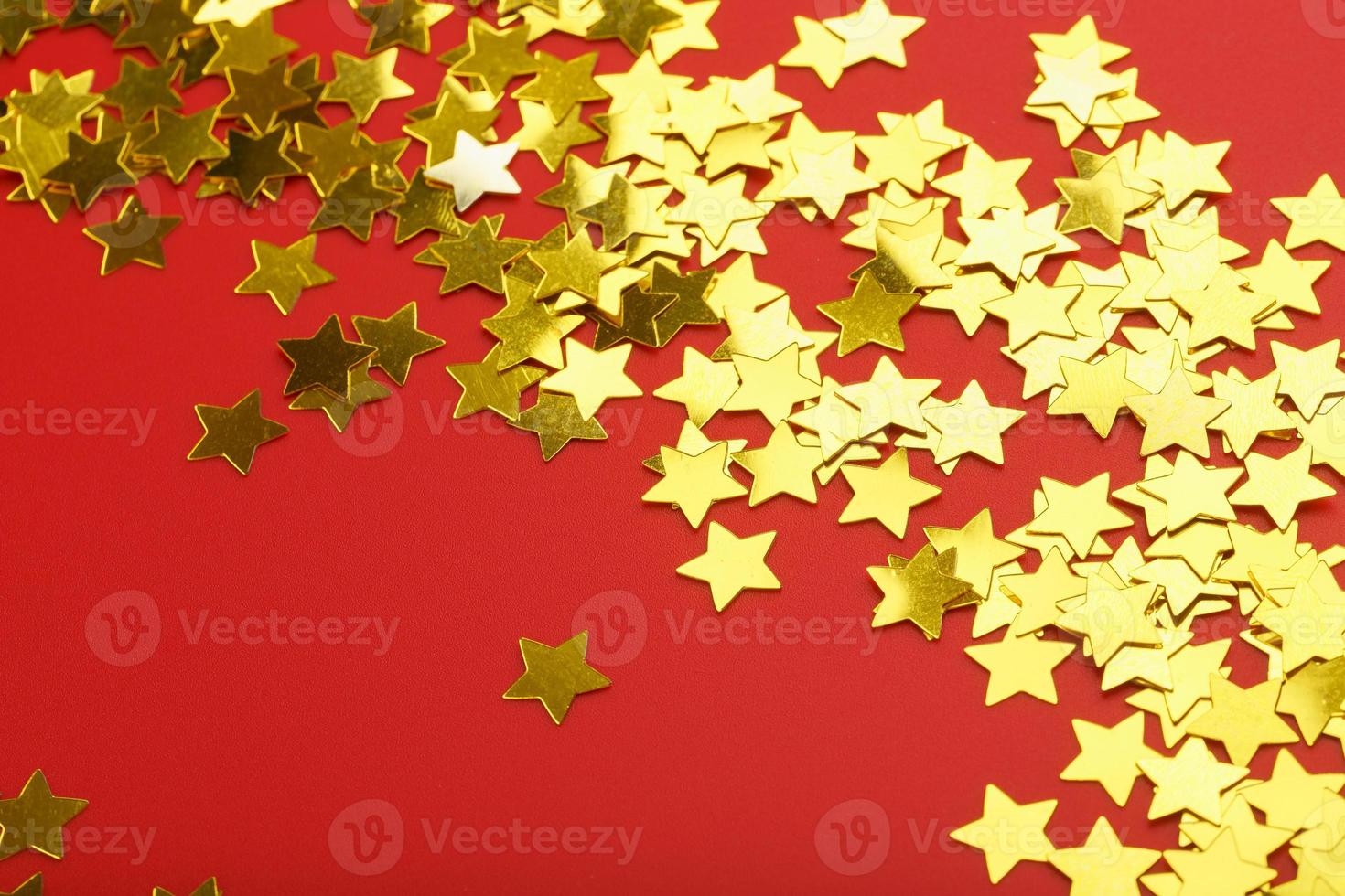 A scattering of Golden stars on red background. The concept of greeting cards, headlines and web site. photo