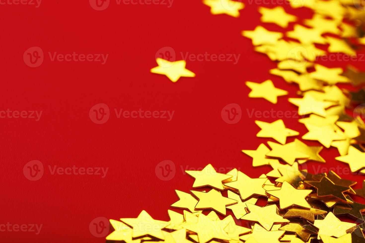 A scattering of Golden stars on red background. The concept of greeting cards, headlines and web site. photo