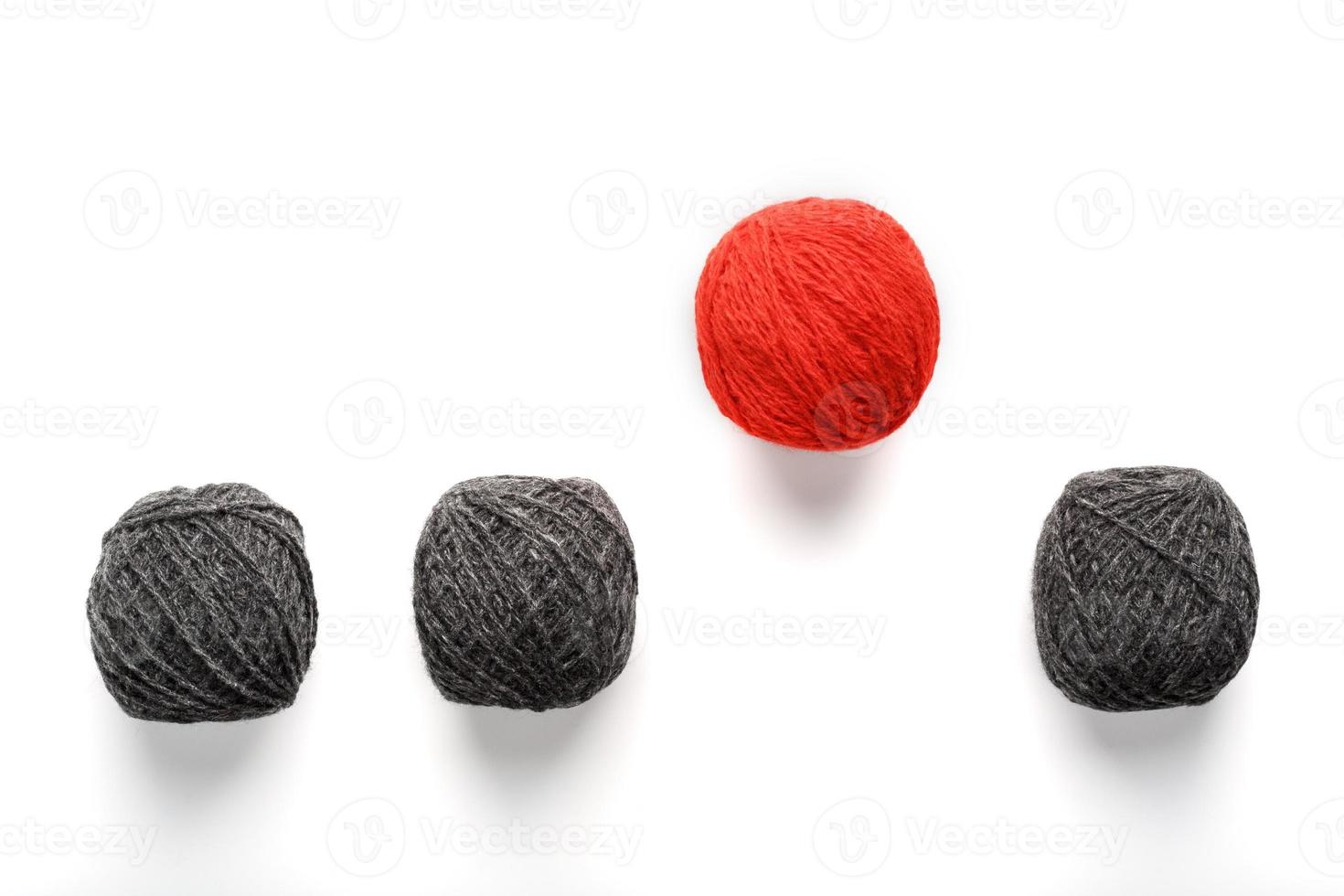 una bola roja única salta de una fila de bolas de lana idénticas. concepto abstracto de liderazgo, foto