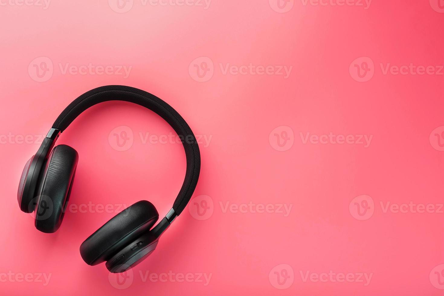 auriculares inalámbricos negros sobre un fondo rosa. Audífonos aéreos aislados de calidad profesional para DJ y músicos foto