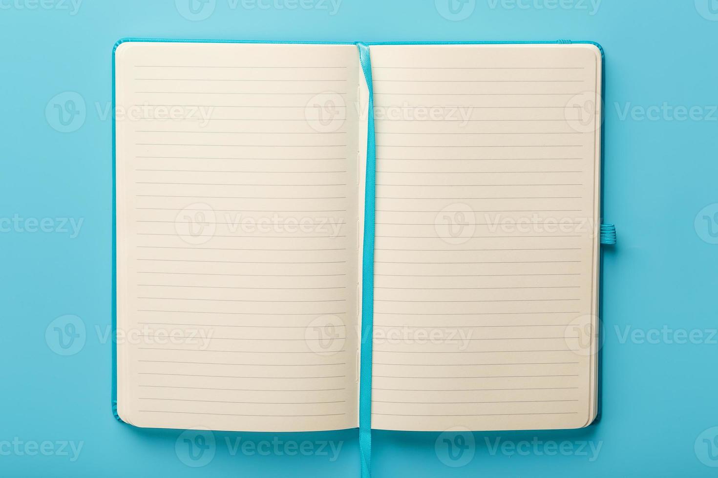 Open notebook, a book with blank and blank pages on a blue background, top view. photo