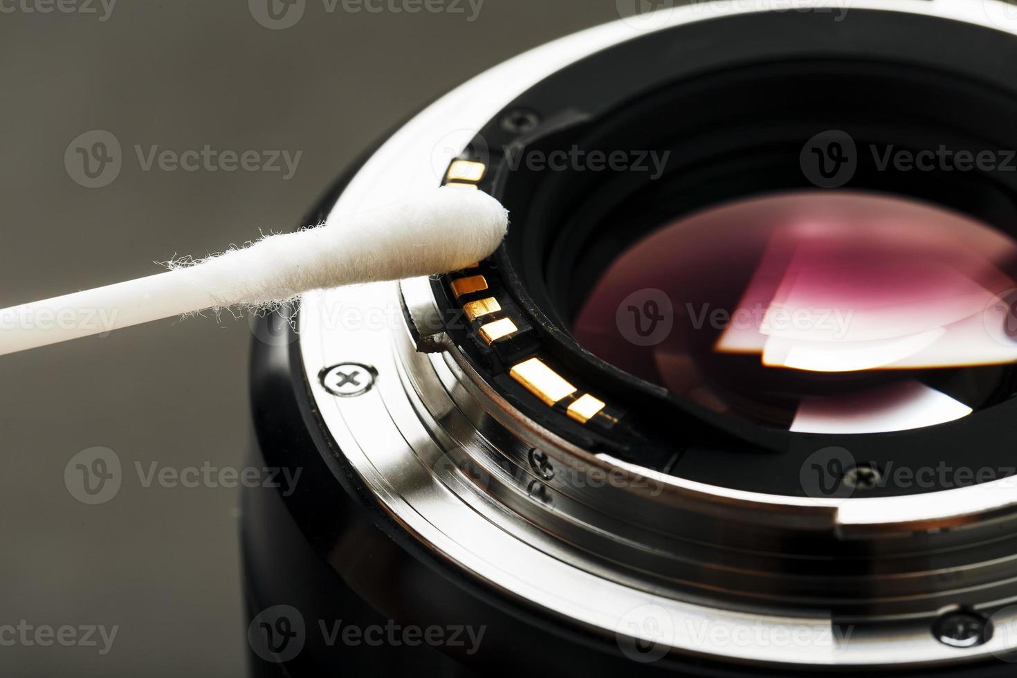 Gentle cleaning with a cotton swab camera Lens with a beautiful optical block close-up. photo