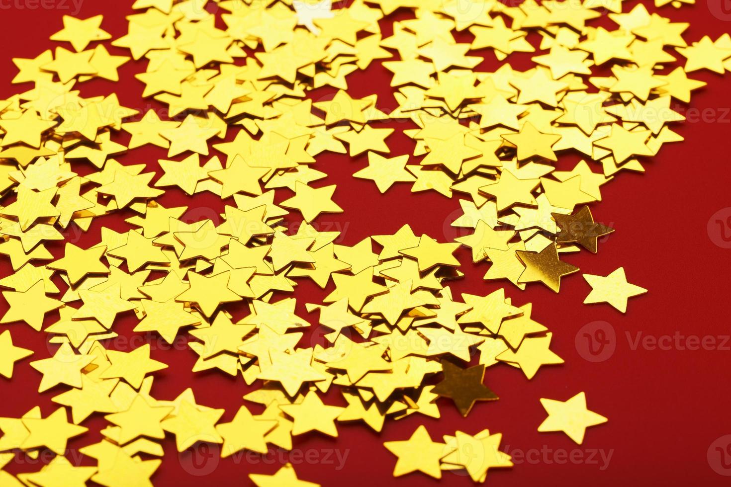 A scattering of Golden stars on red background. The concept of greeting cards, headlines and web site. photo