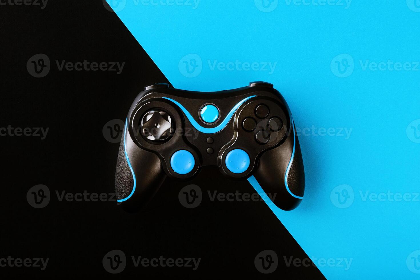 Black gamepad on black and blue background, by . Game concept. Device to control and control the game. photo